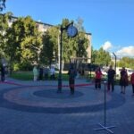 Городская скульптура из бронзы в виде фигуры мужчины с букетом цветов