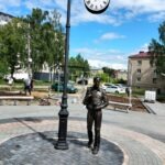 Городская скульптура из бронзы в виде фигуры мужчины с букетом цветов
